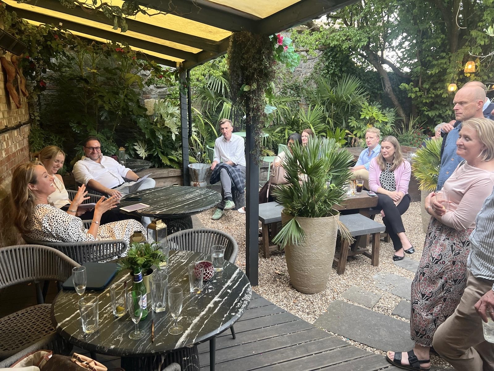 Members listening to the fireside chat in the garden