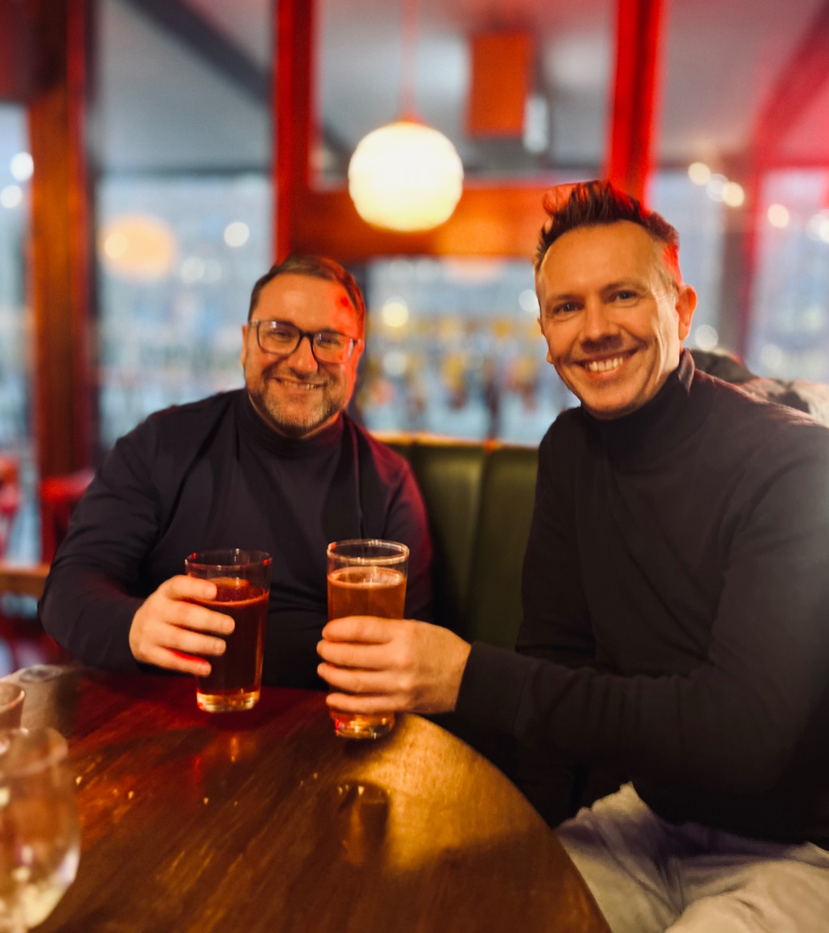 Two founders raising a pint together