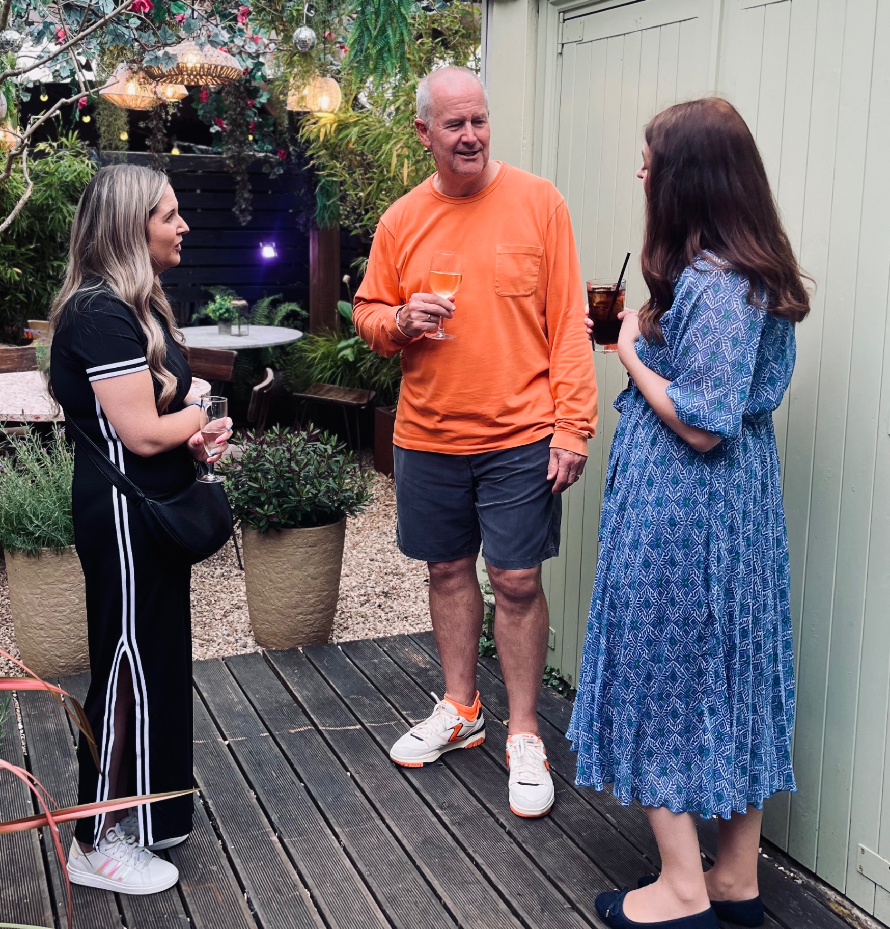 Three founders talking over drinks outside