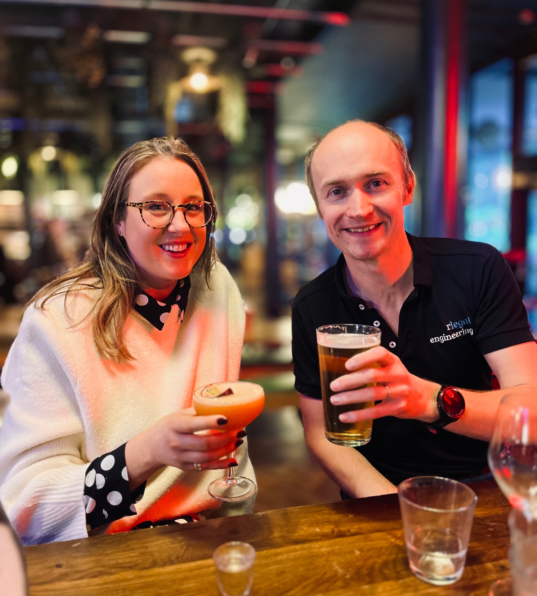 Two members toasting with cocktails at the bar