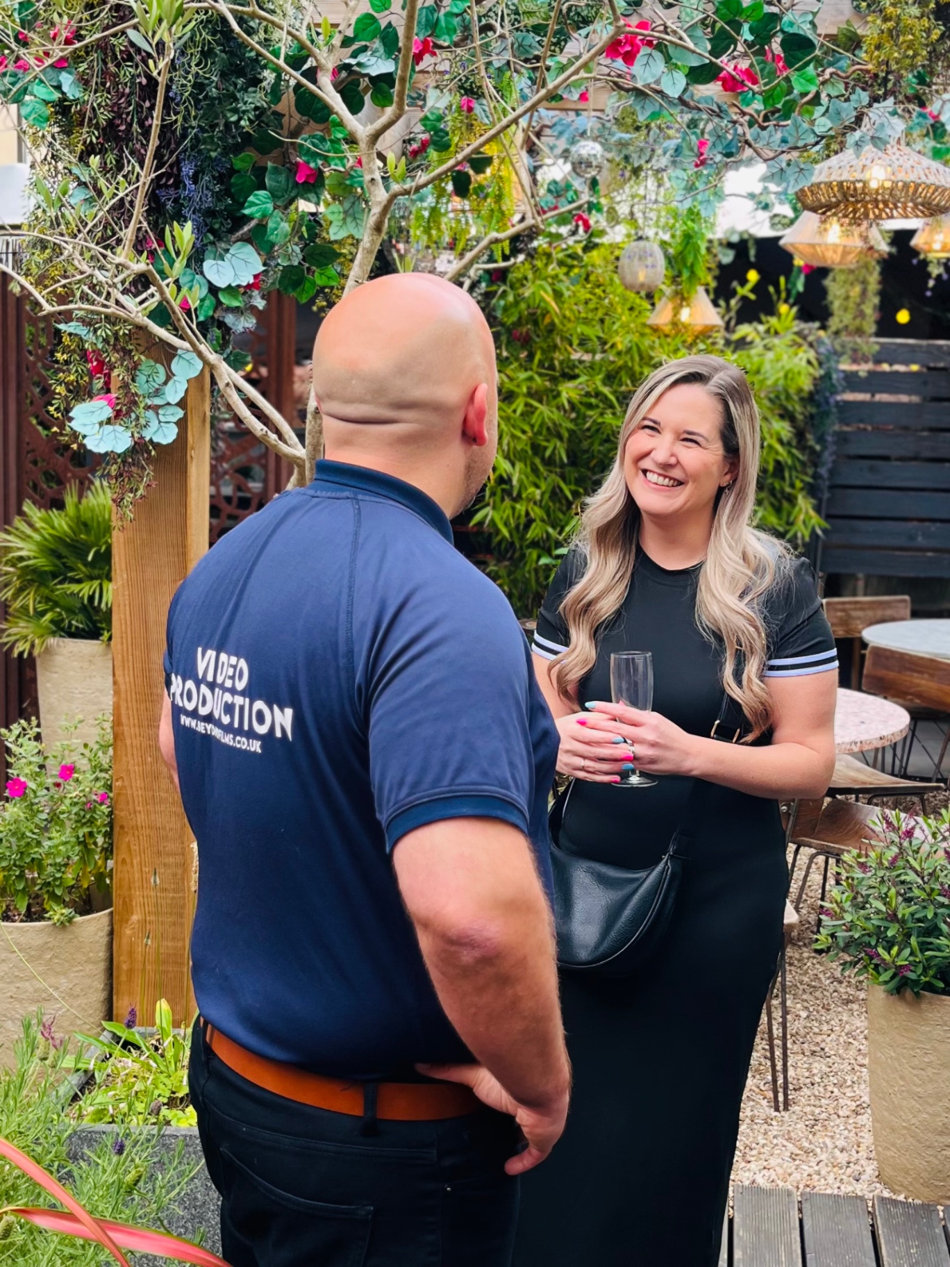 Two members chatting over drinks in the garden