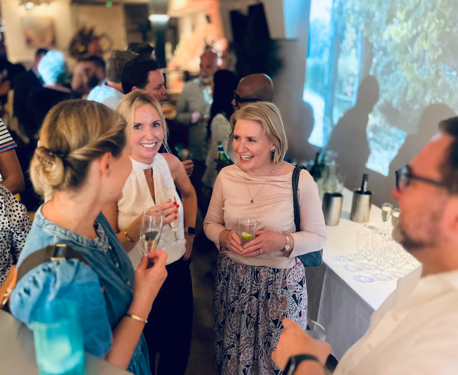 Guests networking with drinks indoors
